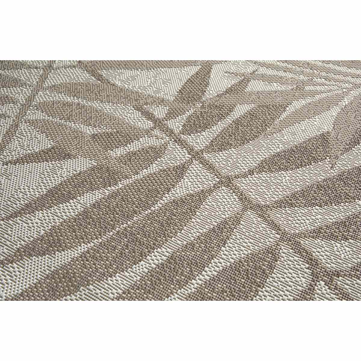 Close-up van een beige tapijt met een bladerpatroon, gedetailleerde textuur.