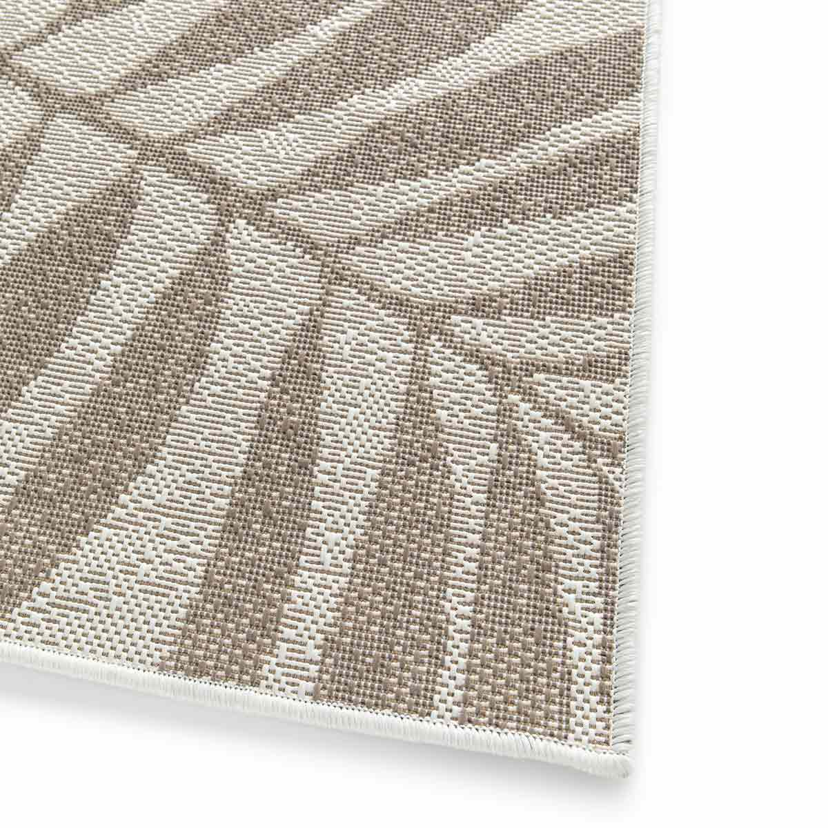 Close-up van het beige en bruine palmbladpatroon op witte achtergrond.