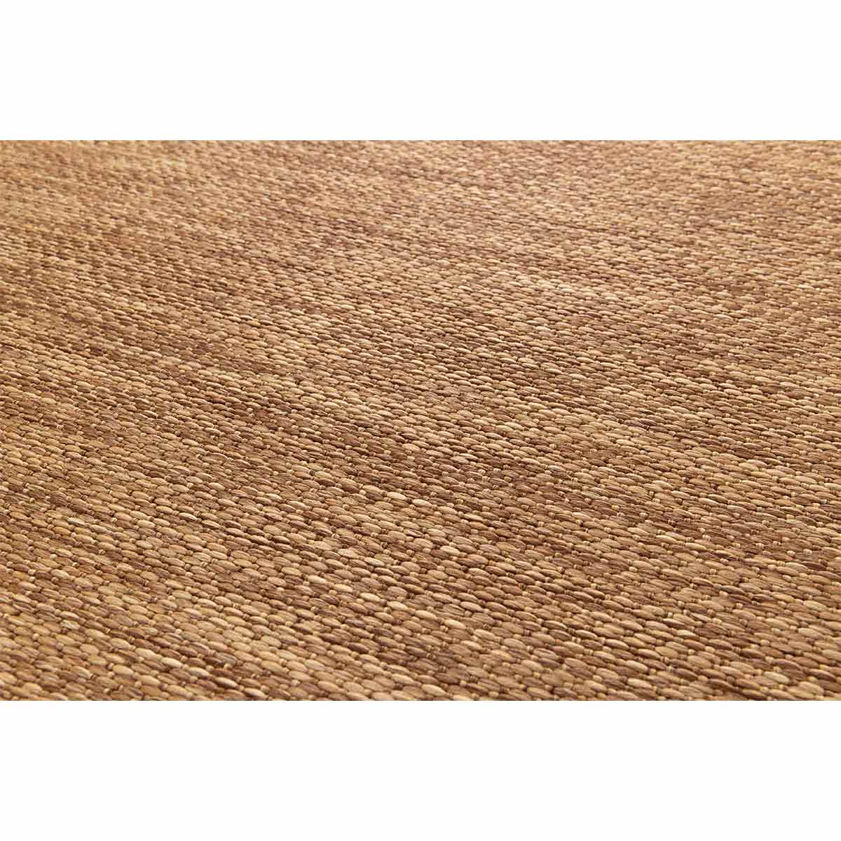 Close-up van een bruin geweven tapijt, gedetailleerde textuur van het materiaal.