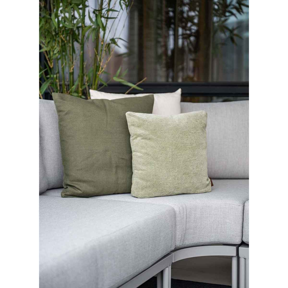 Close-up of pillows on a gray sofa. Green and white pillows.