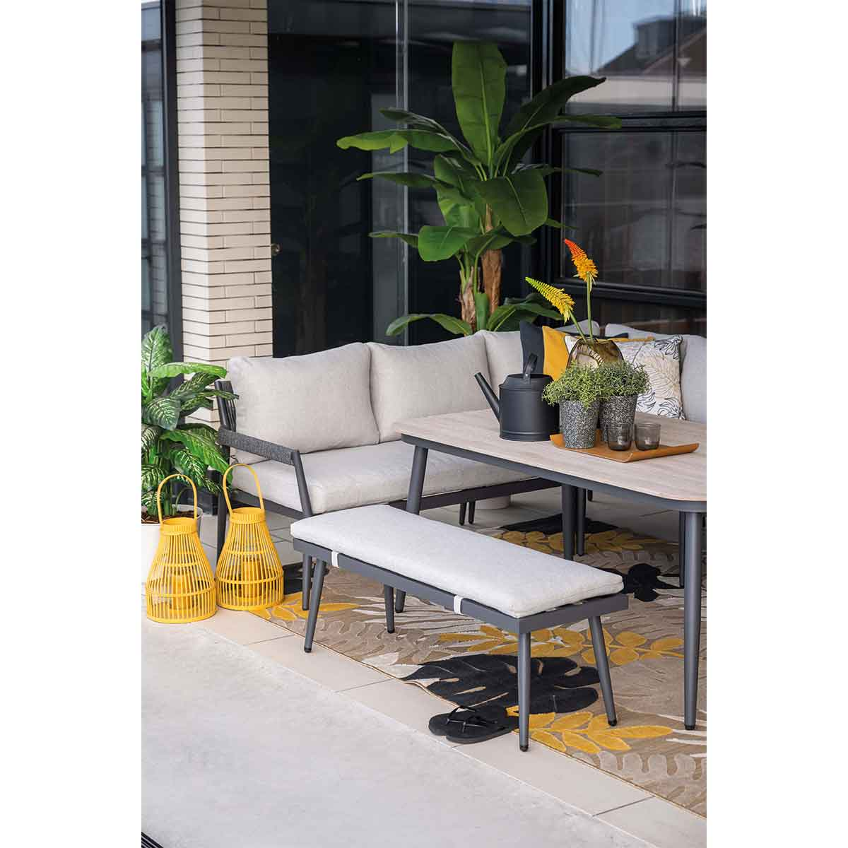 Outdoor seating area with a table, bench, and decorative items.