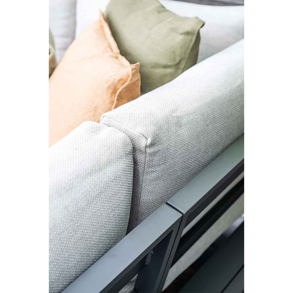 Close-up of grey cushions on a grey and dark frame sofa. Orange and green cushions.