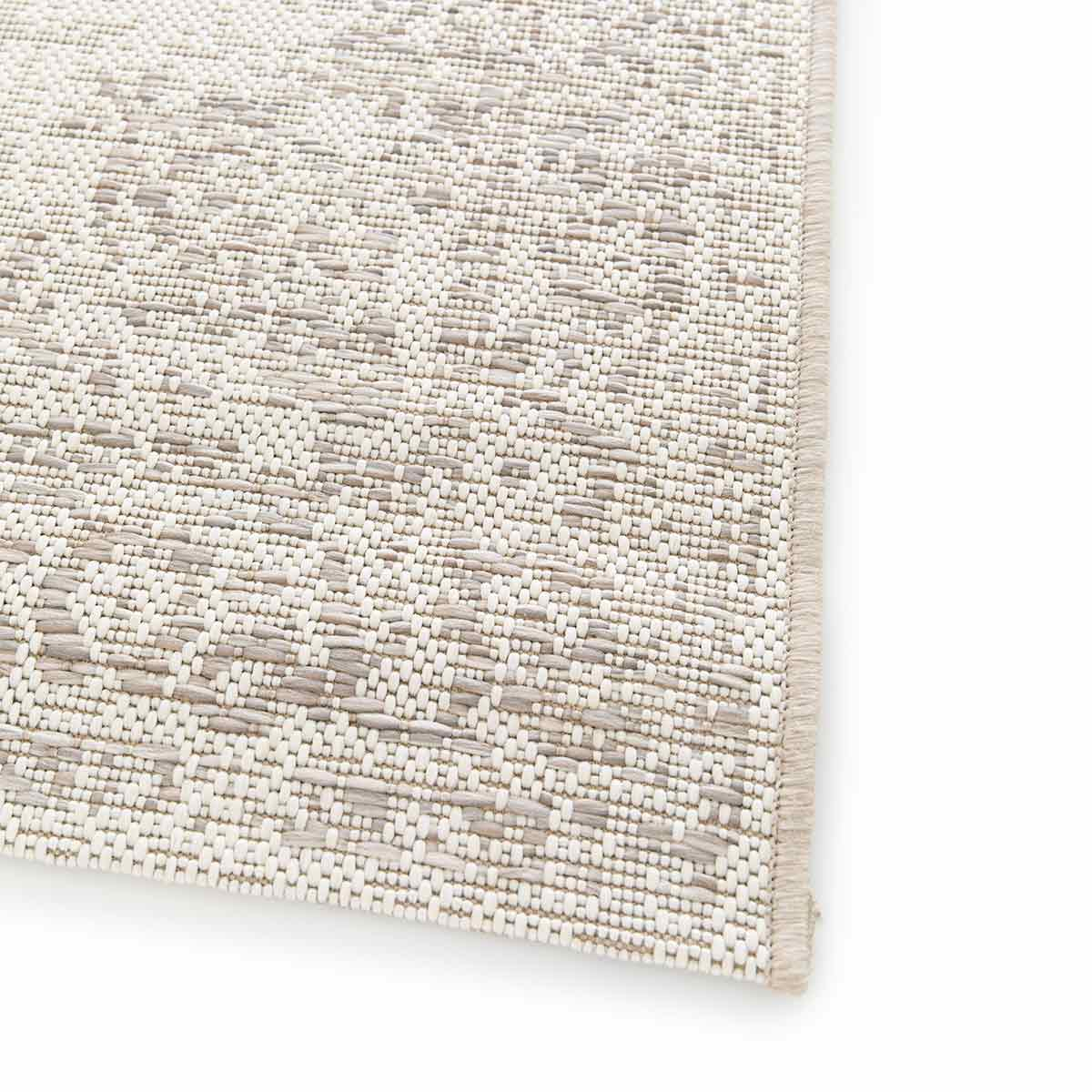 Close-up van een geweven beige buitentapijt.