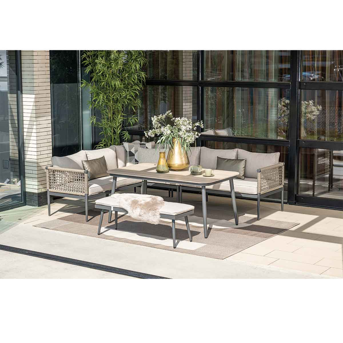 Ensemble de meubles de patio, table, canapé, banc et tapis.