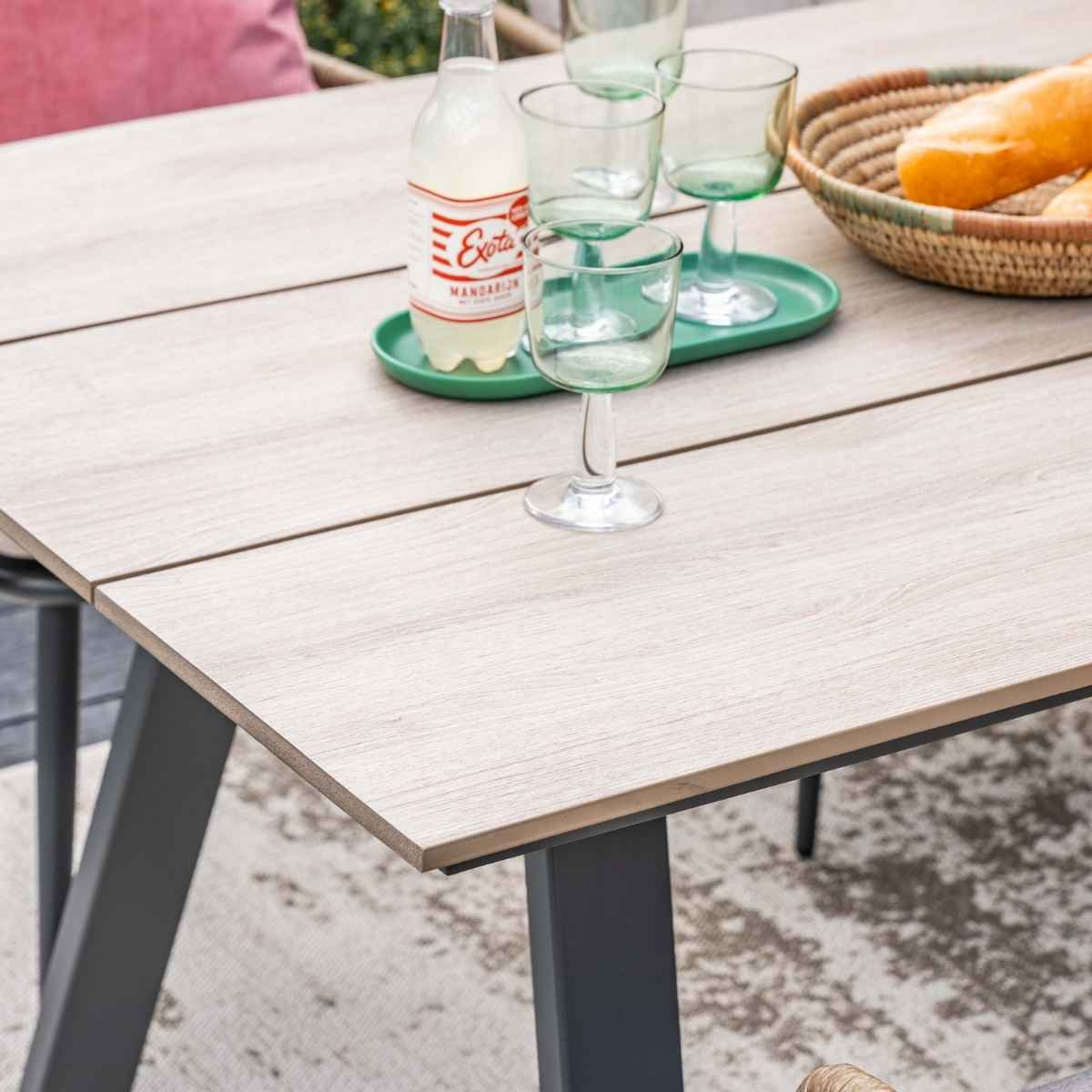 Table with wine glasses, a drink, and a basket of bread.