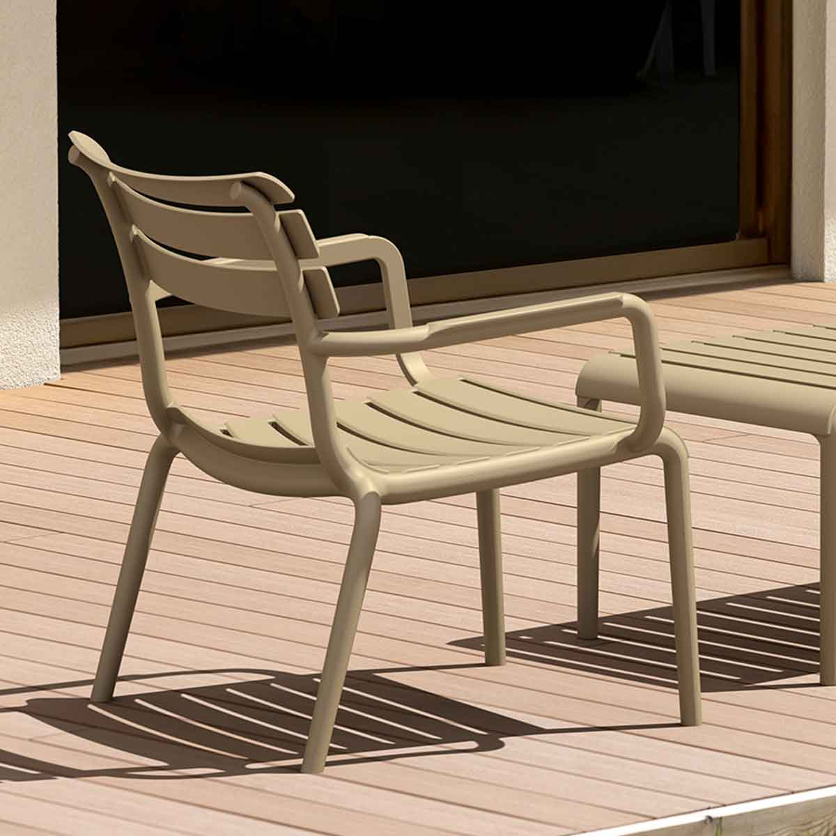 Beige outdoor chair on wooden deck. Slatted seat and back. Sunny day.