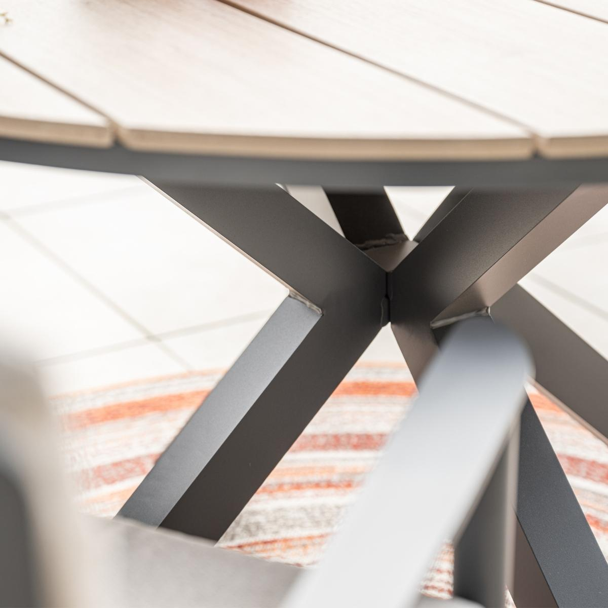 Gros plan sur les pieds de la table. Pieds en métal gris. Tapis blanc et orange.