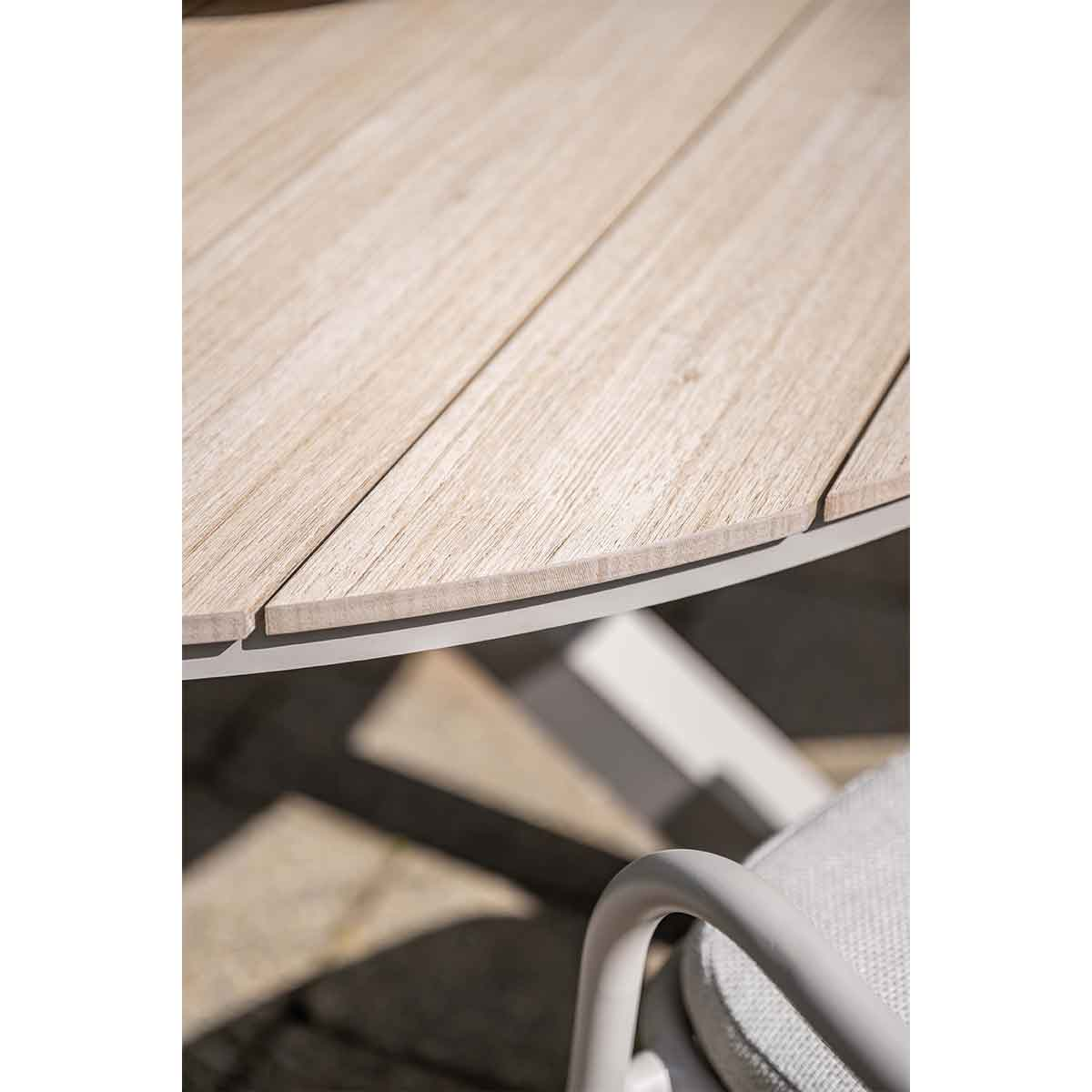 Close-up of a wooden table with a white metal frame and a chair.