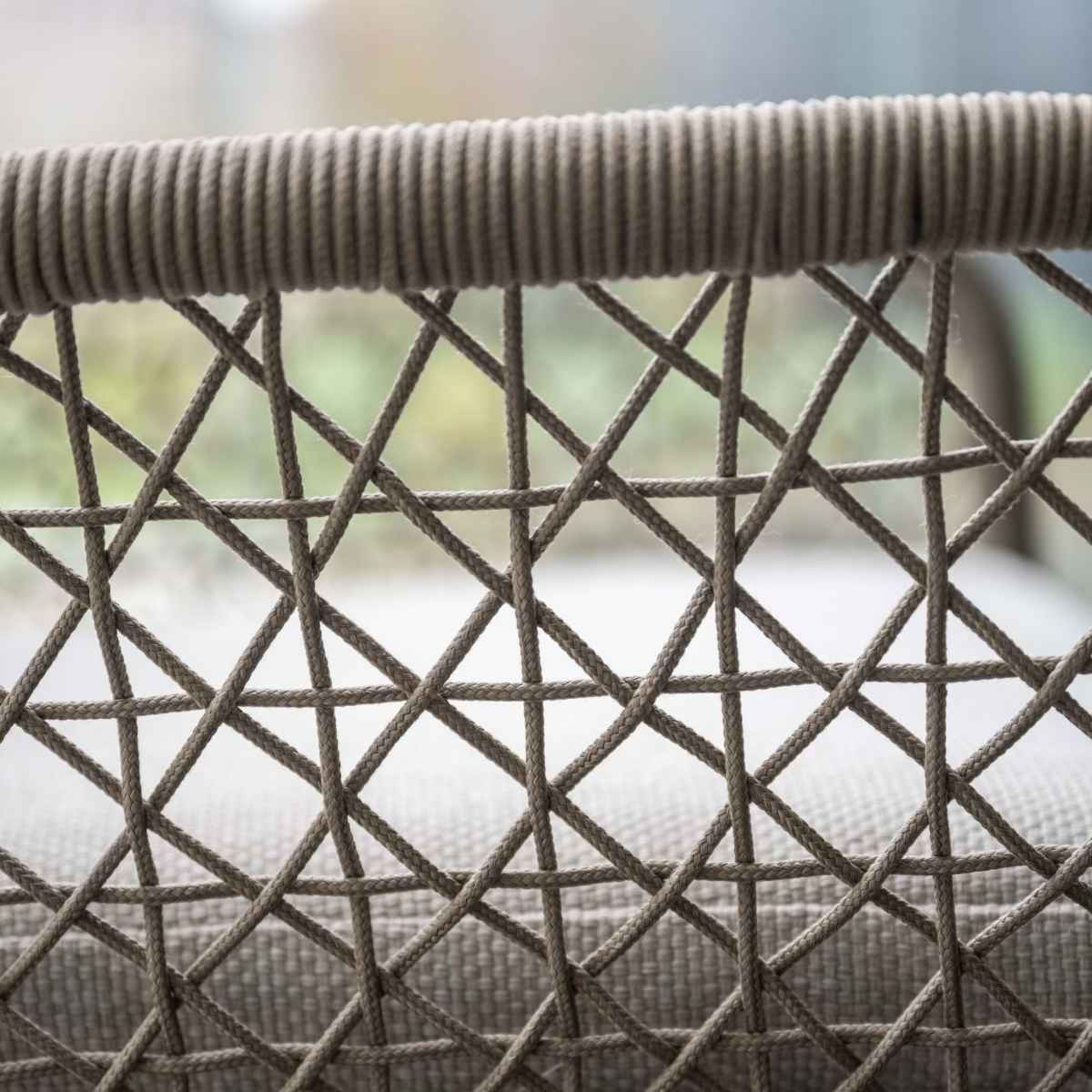 Close-up van de rugleuning van een stoel met gevlochten touw. Bruine touwen vormen een ruitpatroon.