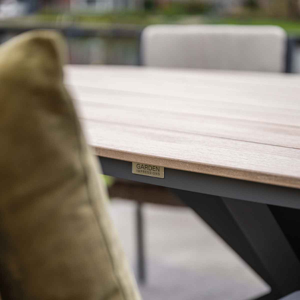 Close-up of a wooden table with a Garden Impressions label on the edge.
