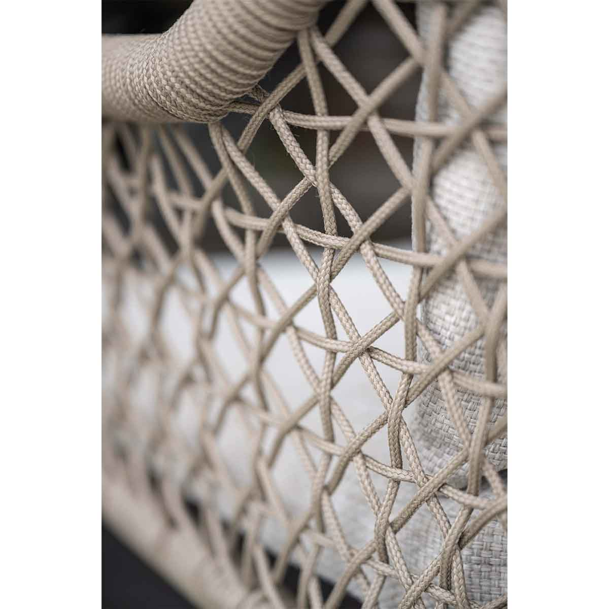 Close-up of wicker chair weave. Beige color, visible texture, creating a pattern.