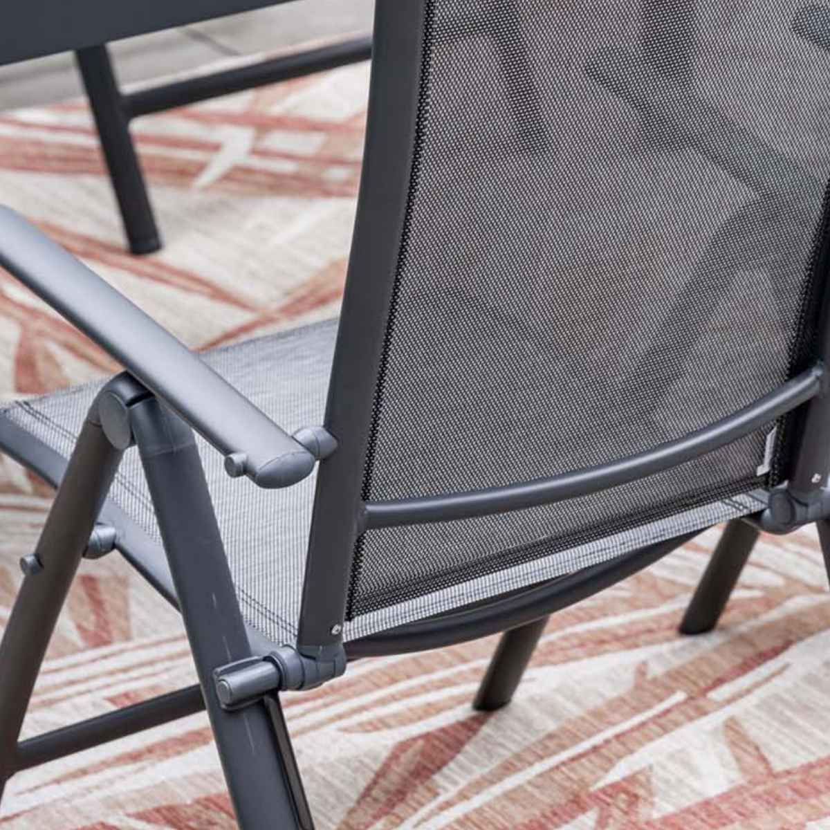 Close-up of a black chair. Metal frame and mesh seat.