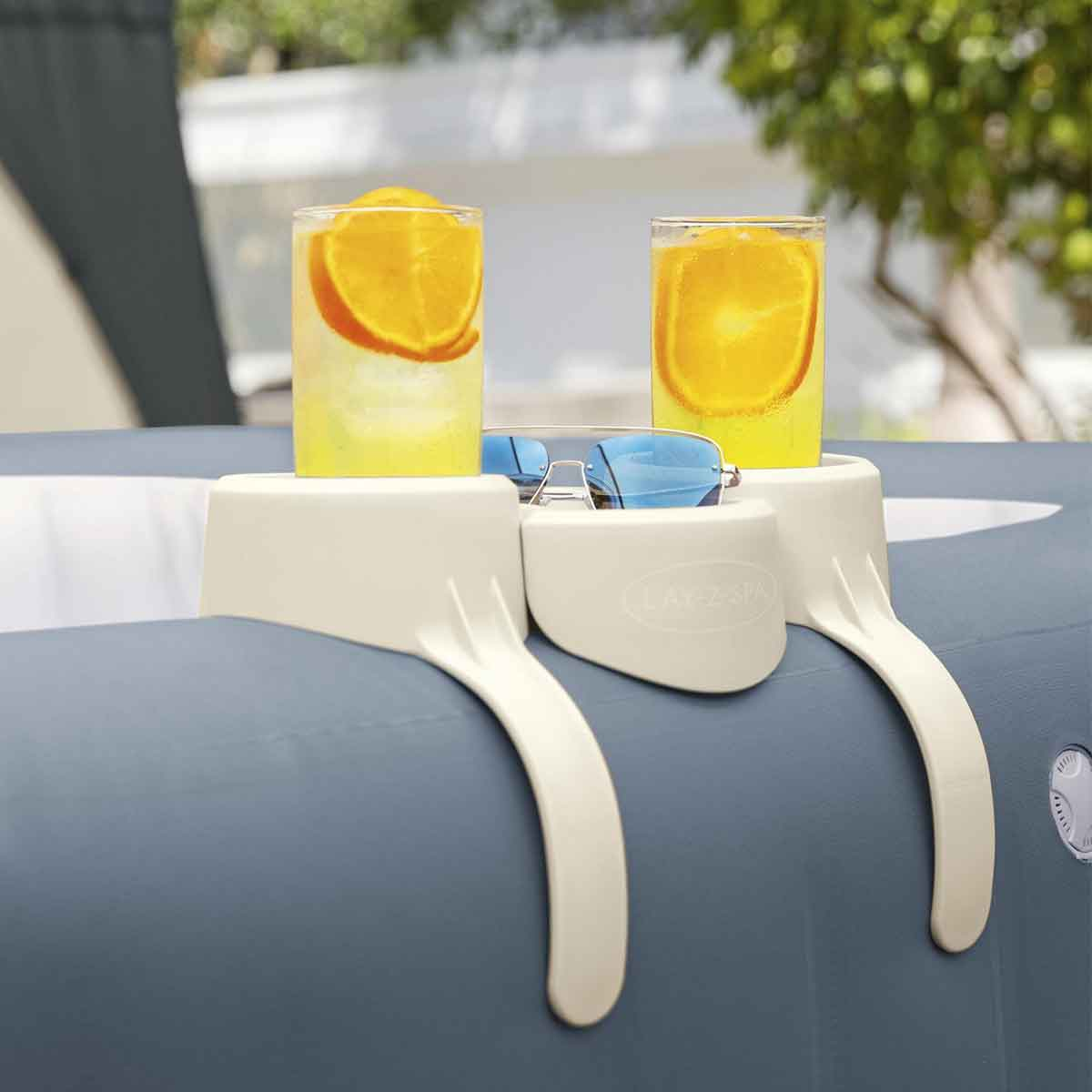Deux verres avec tranches d'orange, lunettes de soleil sur un plateau de jacuzzi.