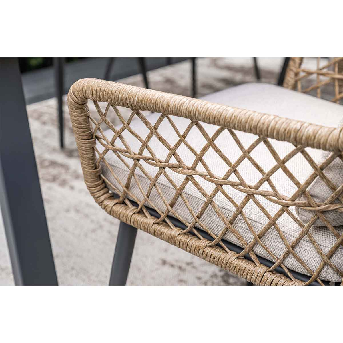A close-up of a woven chair back. The back is made of light brown woven material.