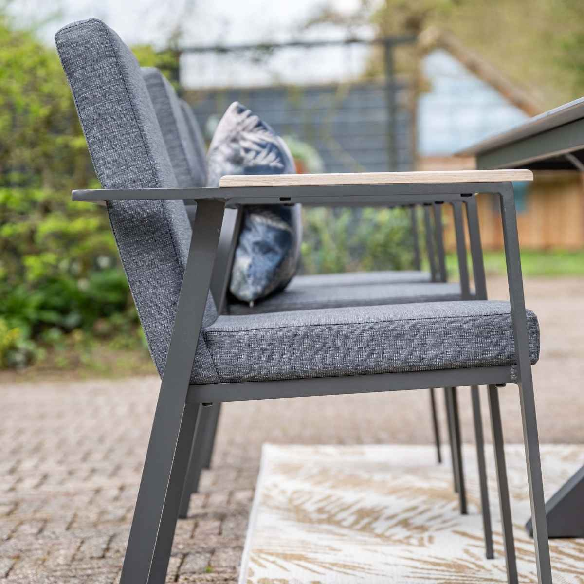 Stoelen in de tuin, naast de tafel geplaatst, klaar voor gebruik.