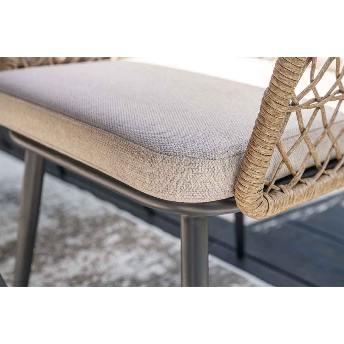 Gros plan sur une chaise en osier avec coussin gris clair. Cadre en métal. Arrière-plan flou.