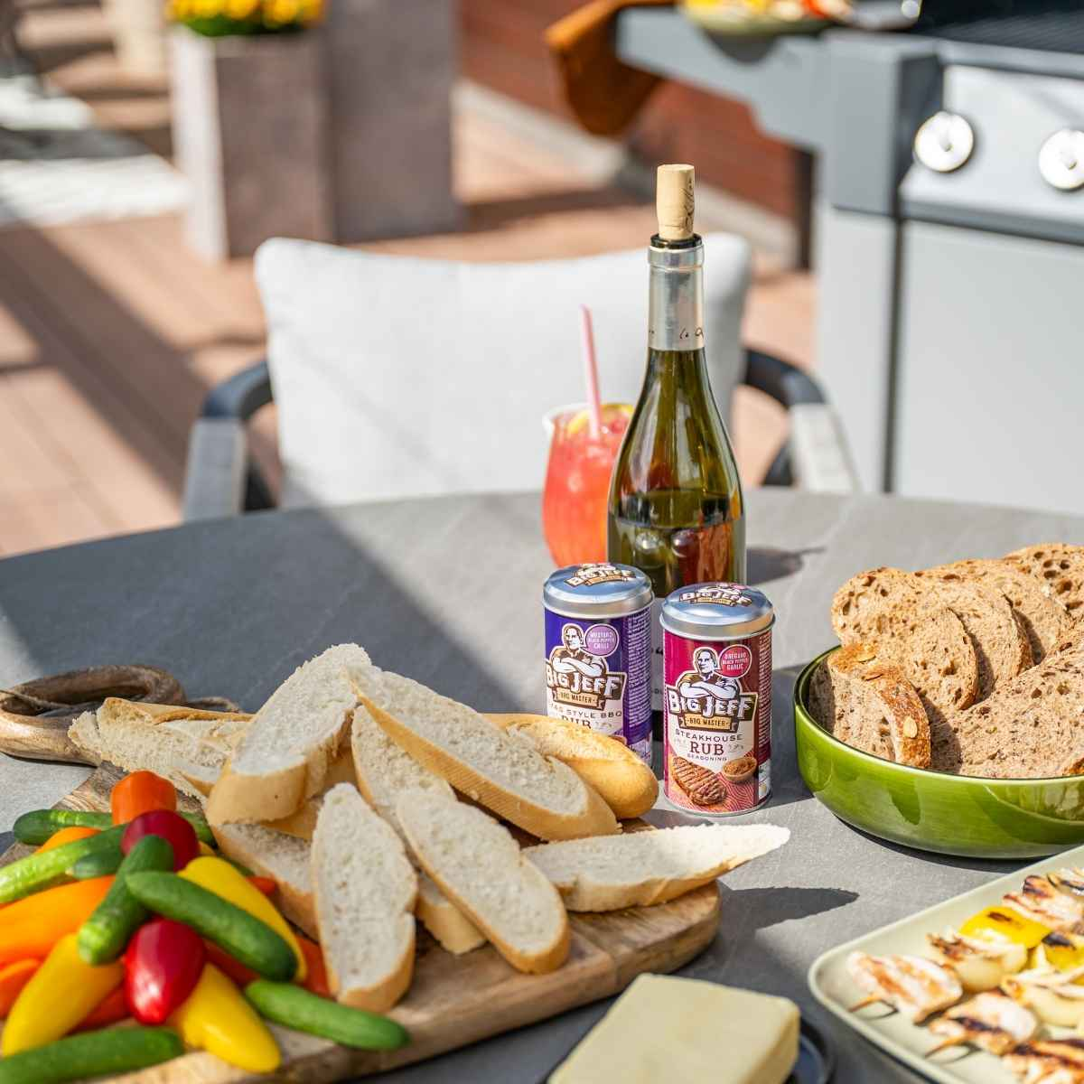 Mensen aan een tafel met eten en drinken. Inclusief wijn, bier en eten. Buitenomgeving.