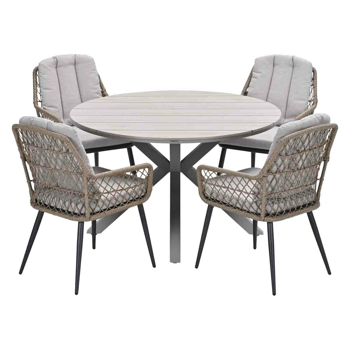 Buiteneetset. Ronde tafel met vier geweven stoelen. Grijze kussens en donkere frames. Witte achtergrond.