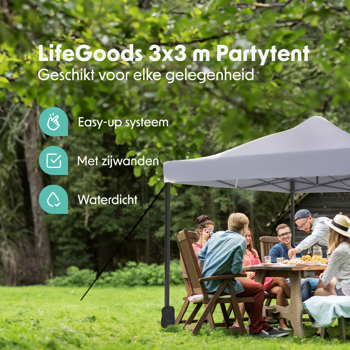 People at a table under a grey tent in a green yard with trees in the background.