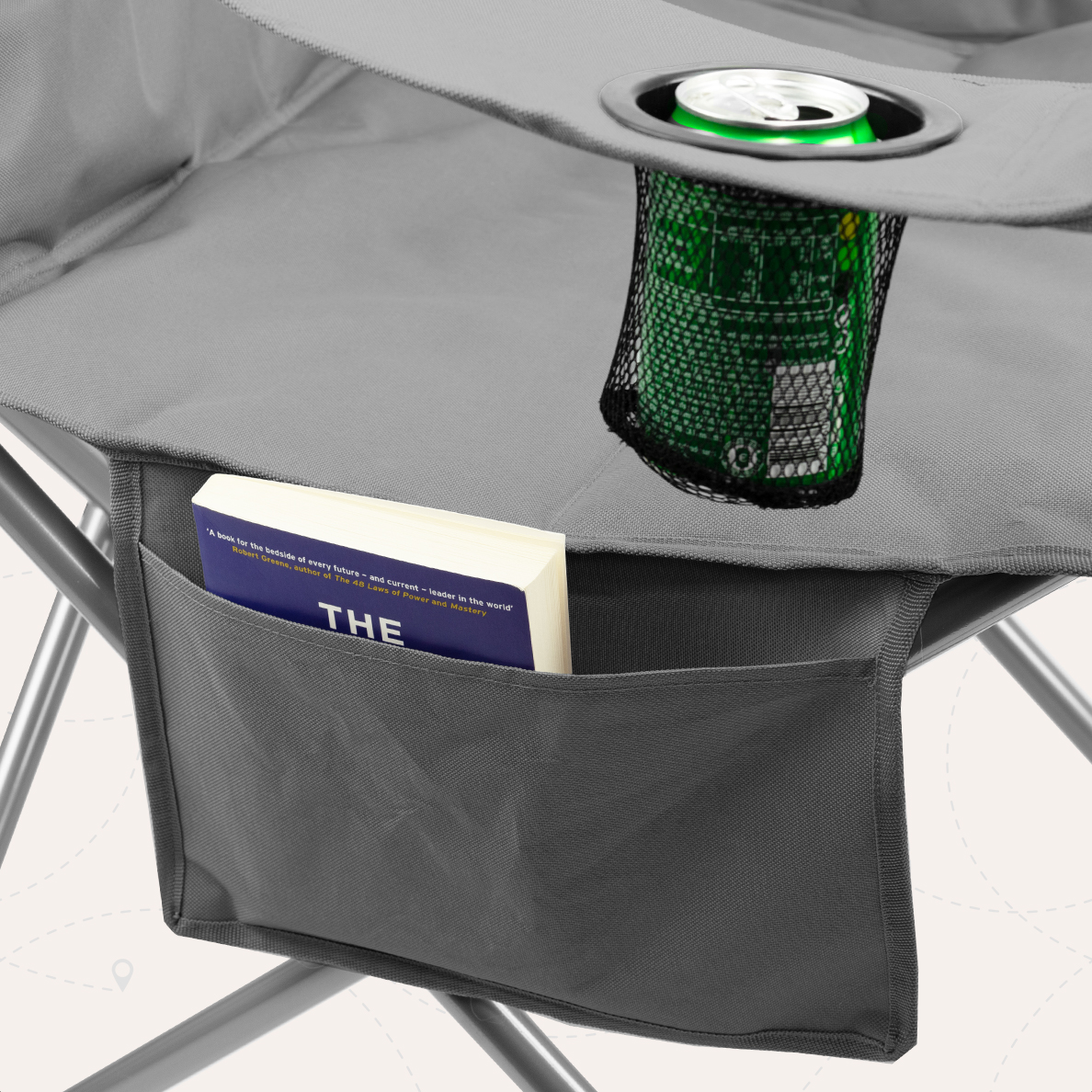 Close-up van een grijze campingstoel met een boek in een zak en een drankje in een mesh houder.