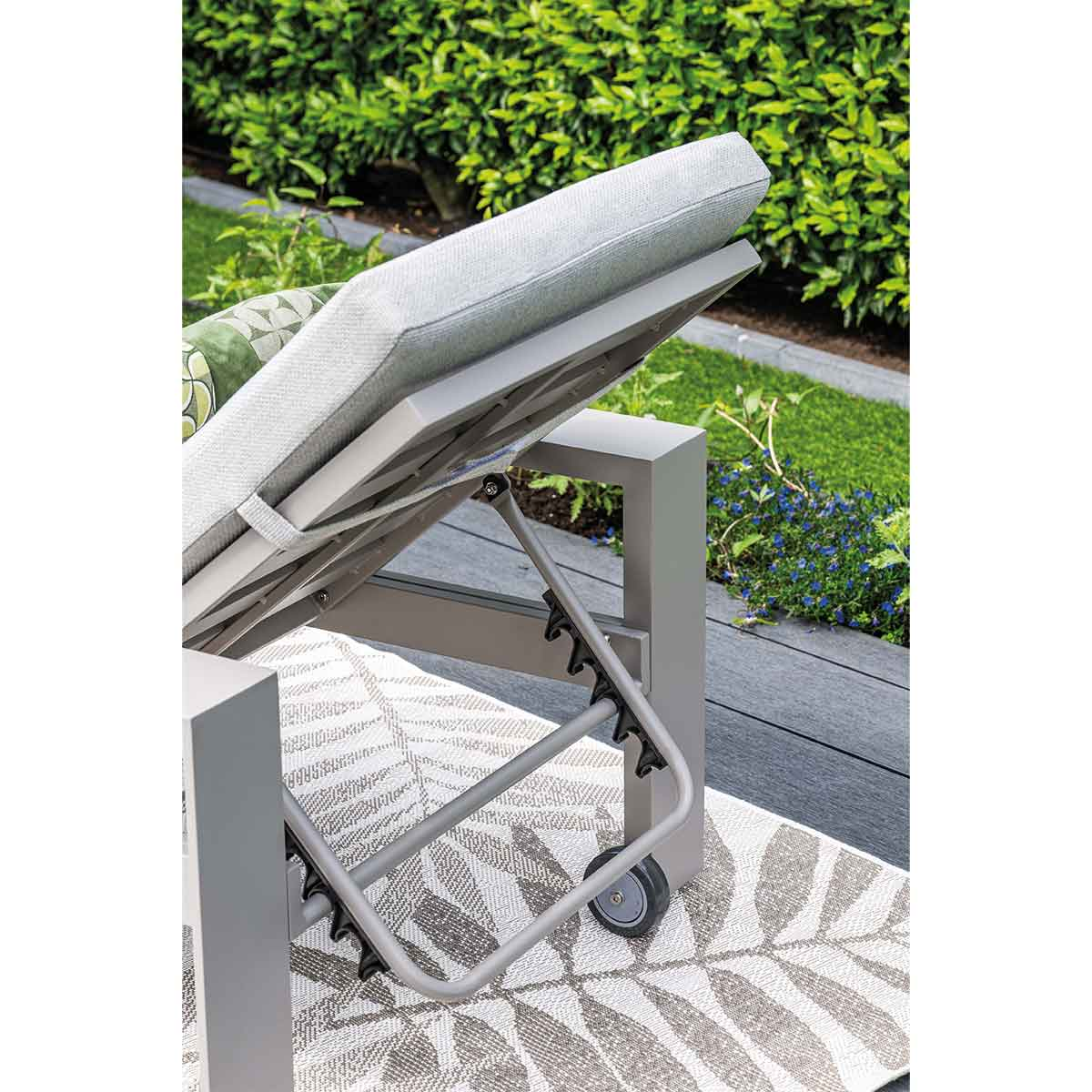 Outdoor furniture with an adjustable back and wheels, shown on a patterned rug.