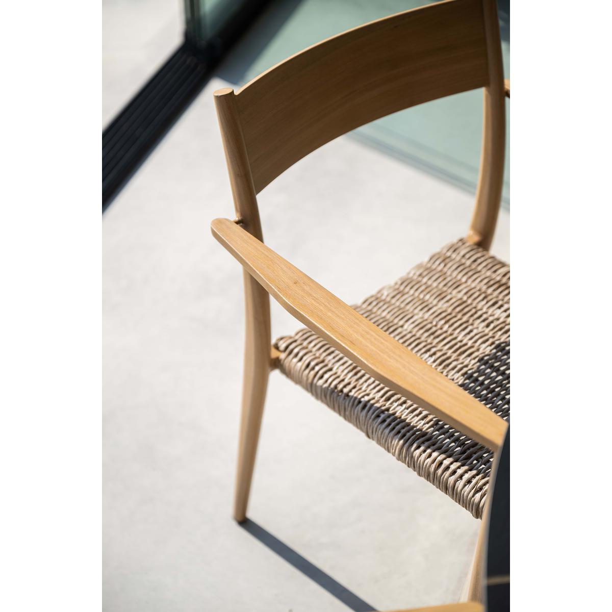 Wooden chair with woven seat. The chair is on a light surface.