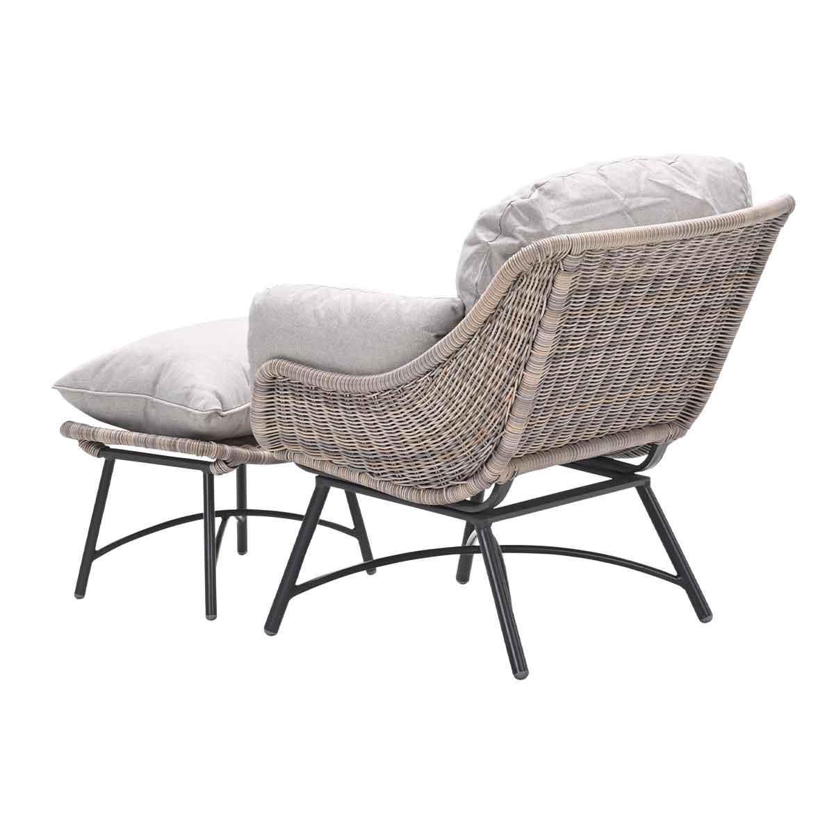 Rattan chair with footrest, light gray cushions, and black metal legs, on a white background.