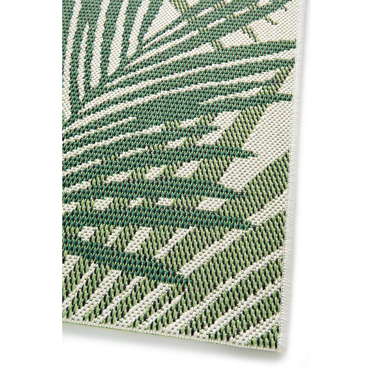 Close-up van een tapijt met bladeren, groen en wit, met een witte rand.
