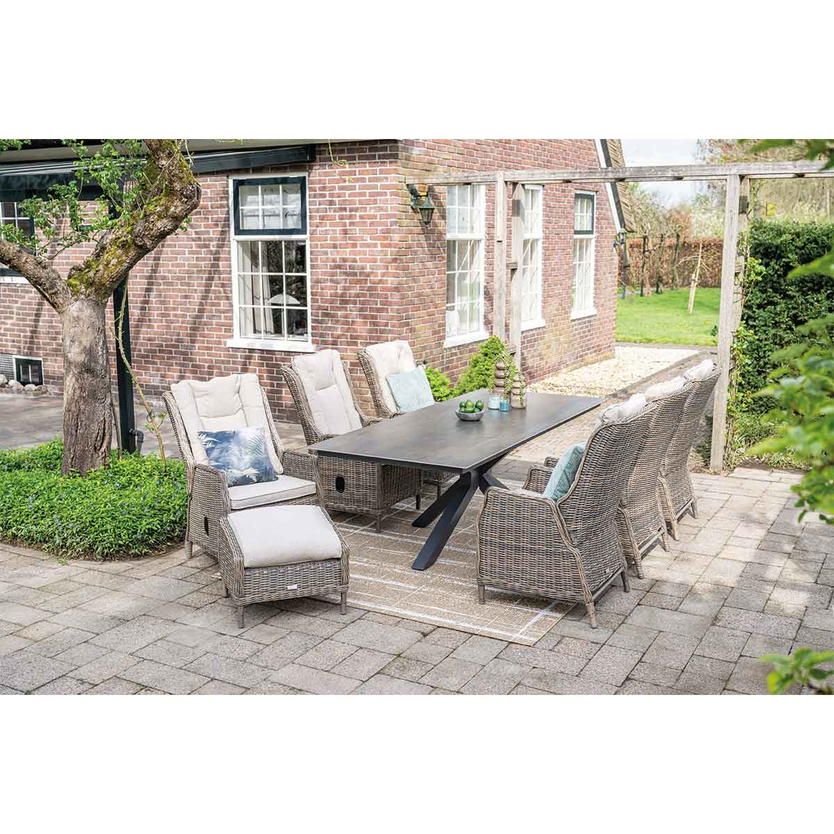 Eetset voor buiten. Rotan stoelen. Tafel en stoelen. Bakstenen achtergrond.