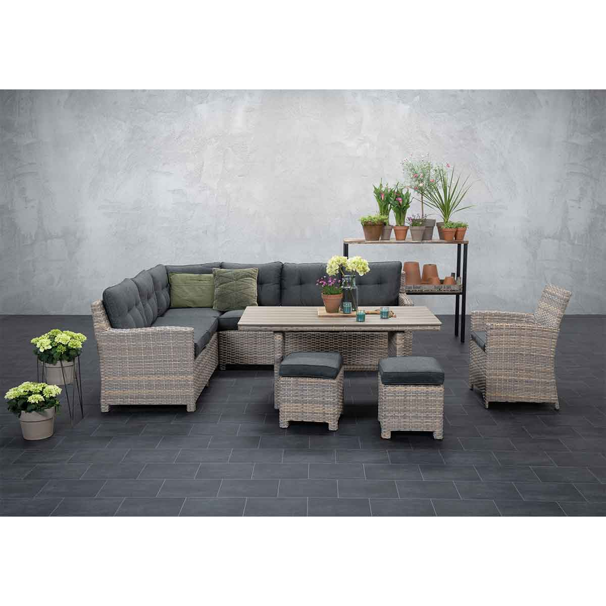 Buitenmeubelset met hoekbank, tafel en stoelen. Planten en donkere vloer.