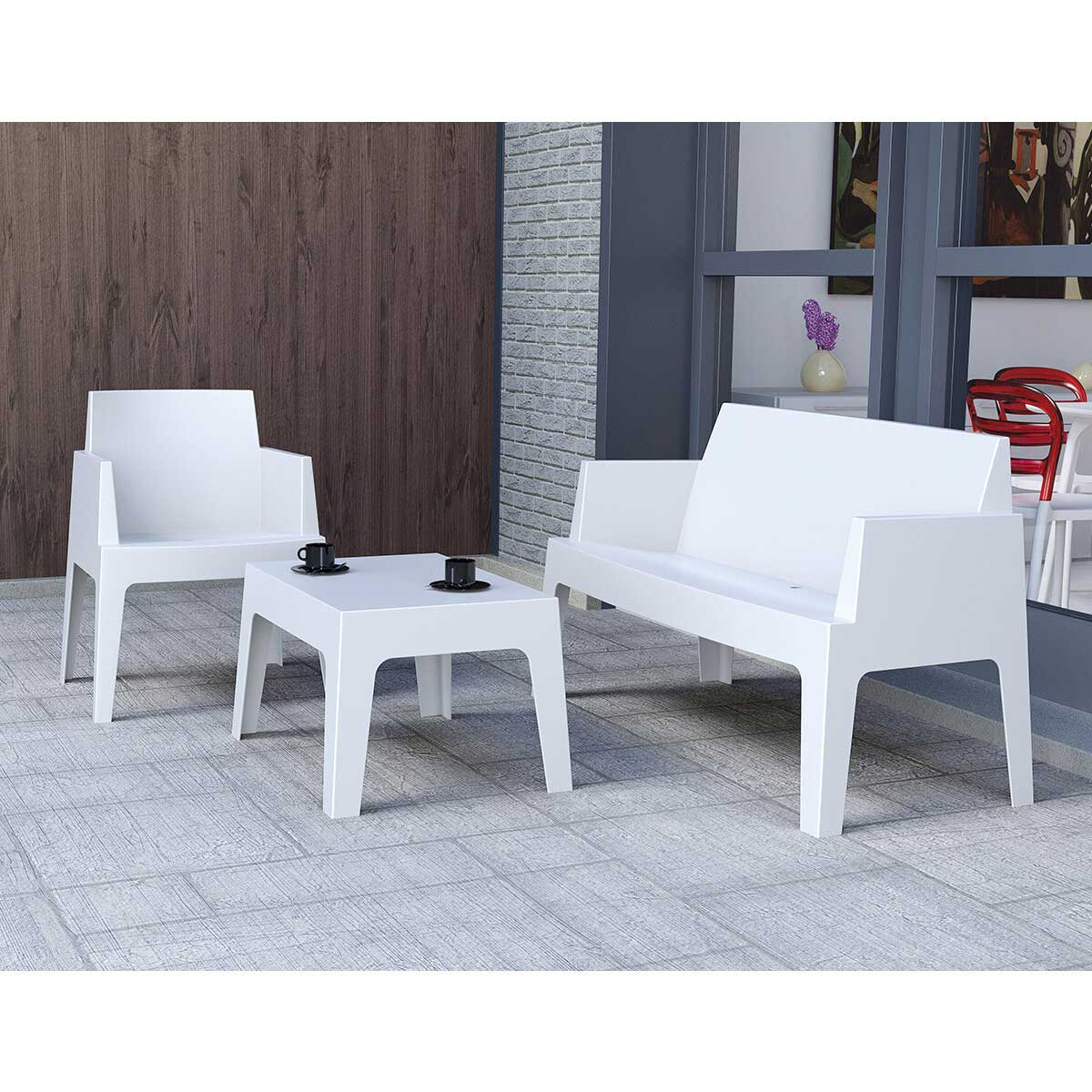 Witte terrasmeubelset: twee stoelen en een kleine tafel. Zwarte koffiekopjes staan op de tafel.