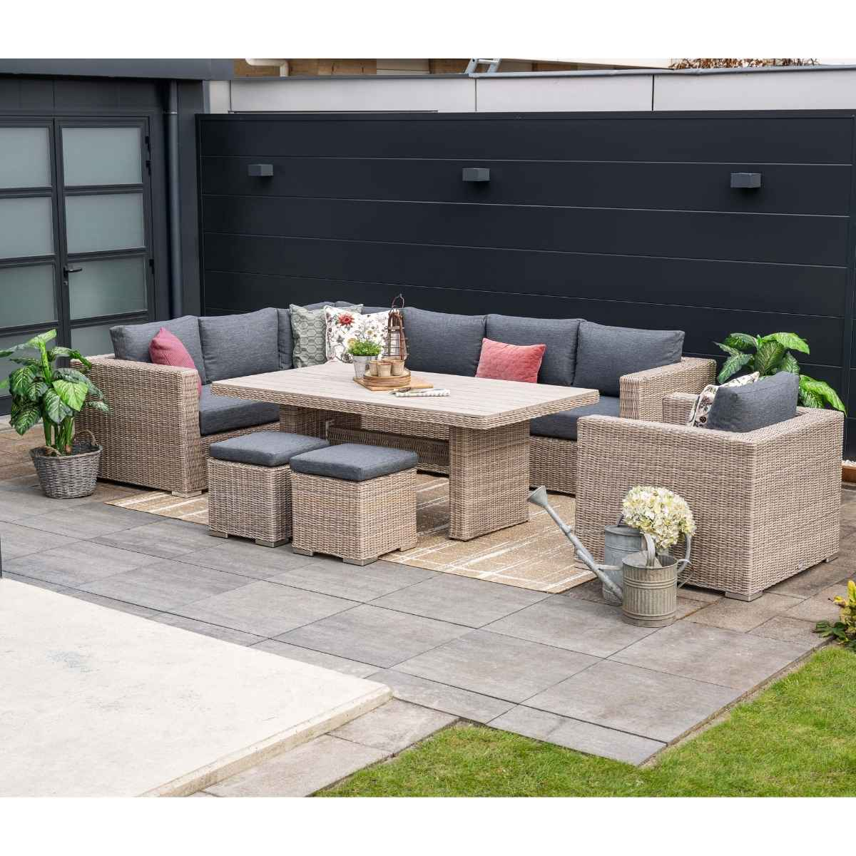 Mobilier de patio extérieur : un grand canapé, une table, des poufs et un arrosoir.