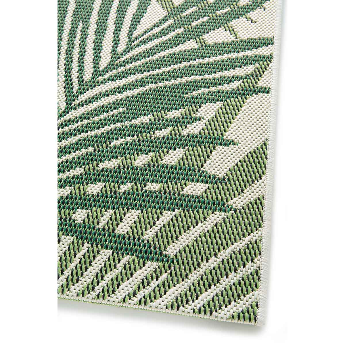Close-up van een groen en wit tapijt met een herhaald patroon van gestileerde palmbladeren.