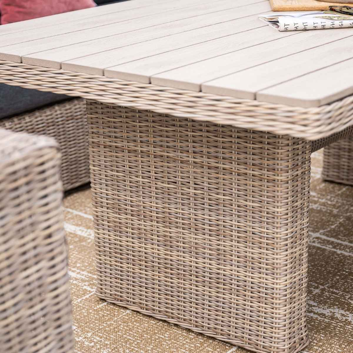 Gros plan sur un pied de table en osier et une partie du plateau.