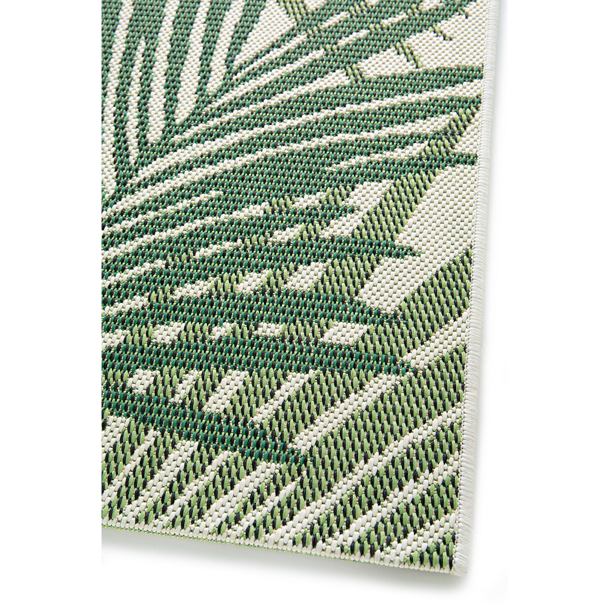 Close-up van een groen en wit geweven tapijt met een palmbladpatroon.