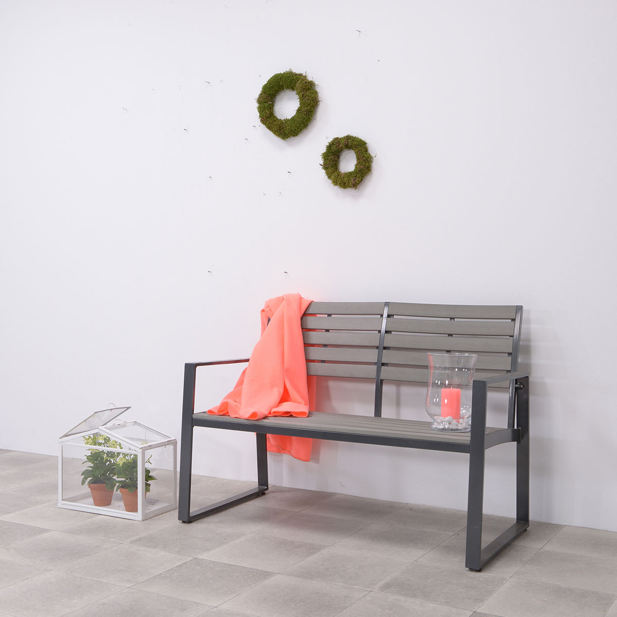 Banc gris avec couverture corail et bougeoir. Fond blanc.