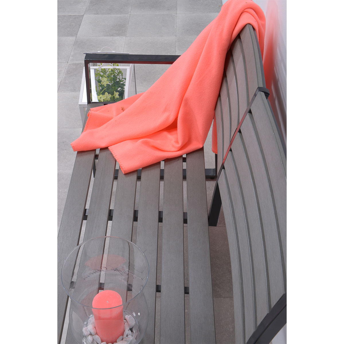 Banc gris avec couverture corail et bougeoir. Fond blanc.