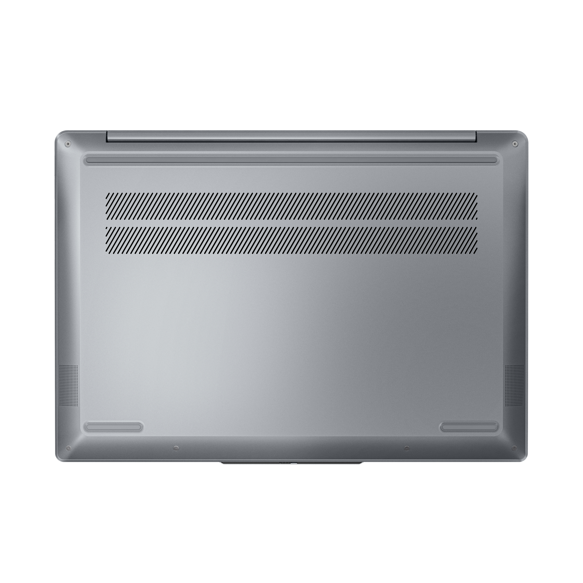 Srebrny laptop od dołu, pokazujący otwory wentylacyjne i głośniki. Białe tło.
