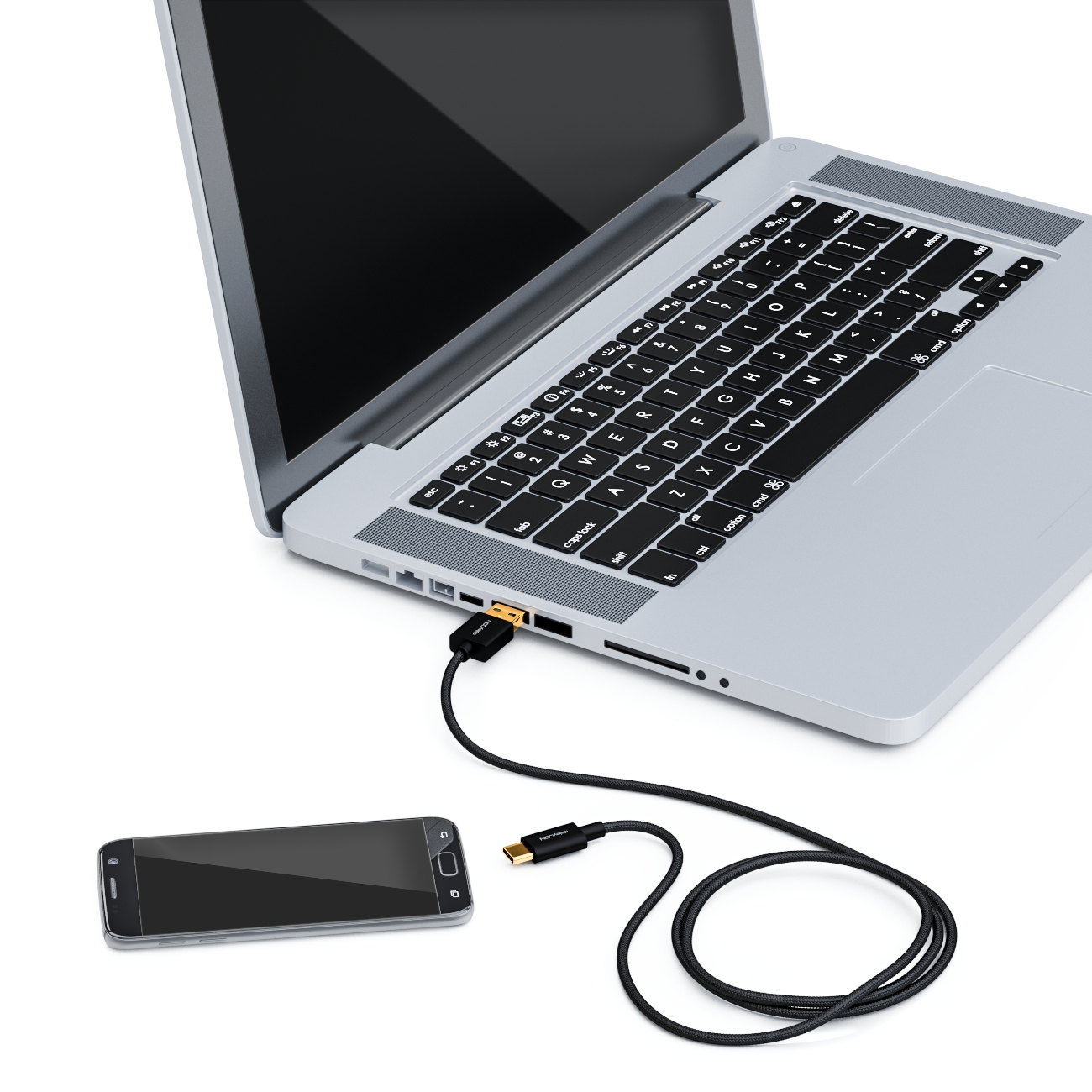 Ein Laptop mit einem schwarzen USB-Kabel, das an ein Telefon angeschlossen ist, auf weißem Untergrund.