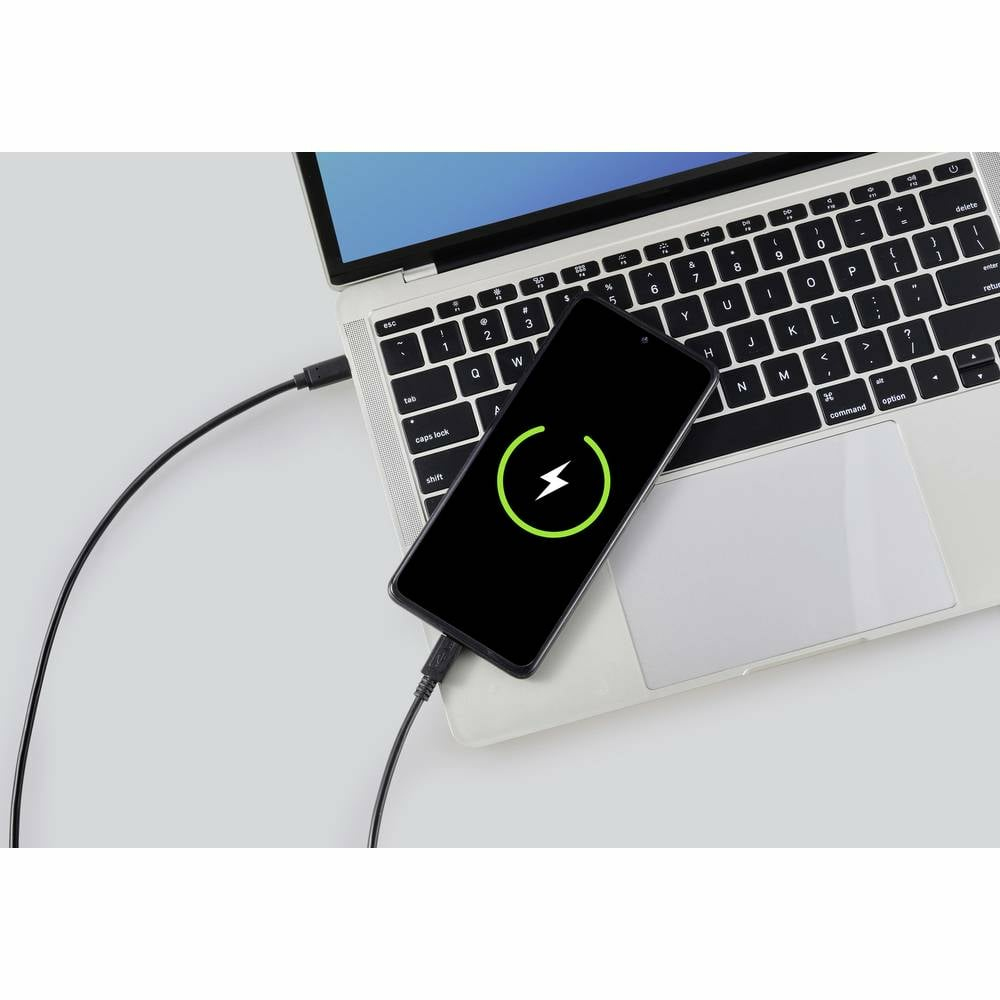 Un telefono si carica su un laptop con un cavo USB-C. Lo schermo mostra un'icona di ricarica verde.