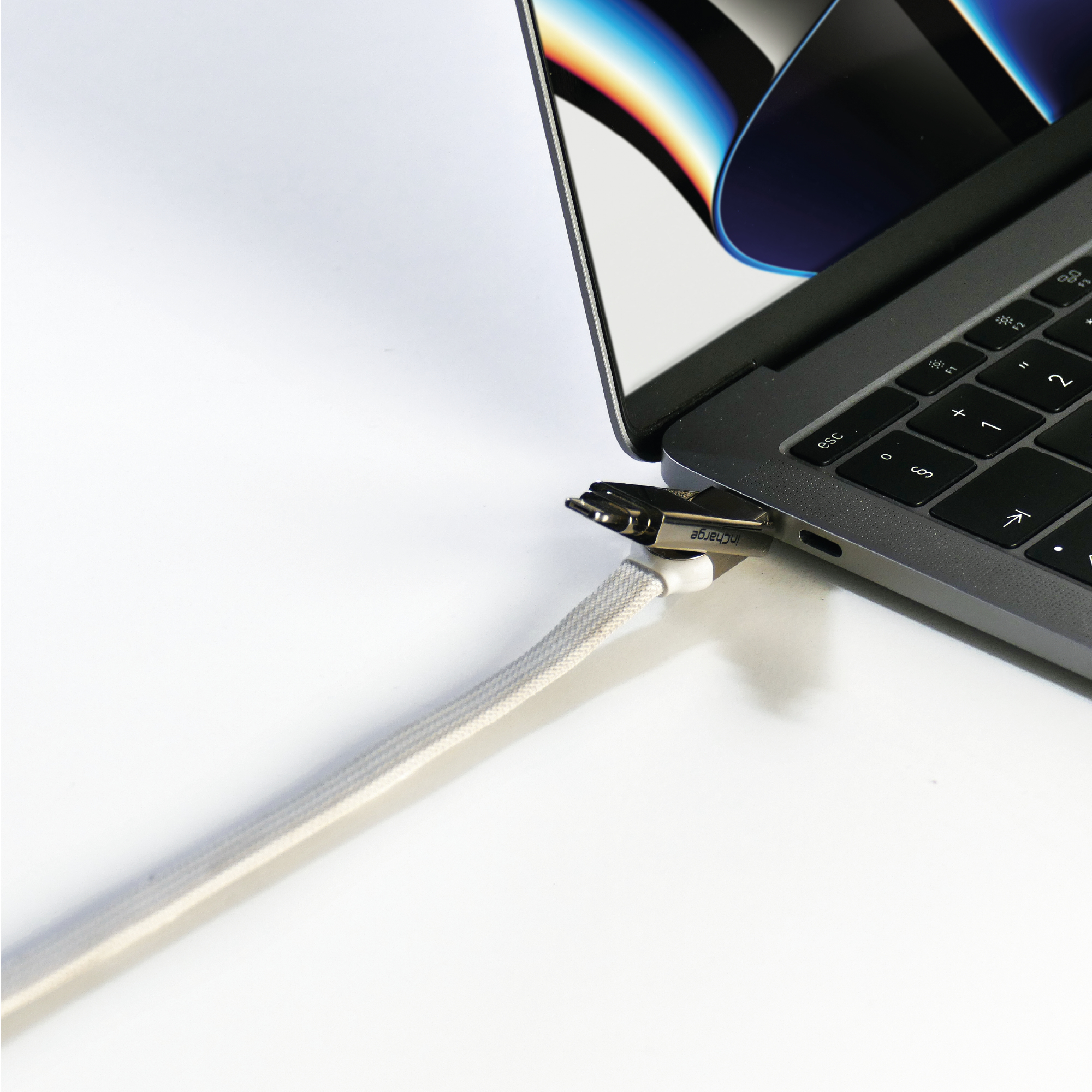 Laptop mit eingestecktem Kabel. Nahaufnahme. Weißes Kabel und Stecker. Weißer Hintergrund.