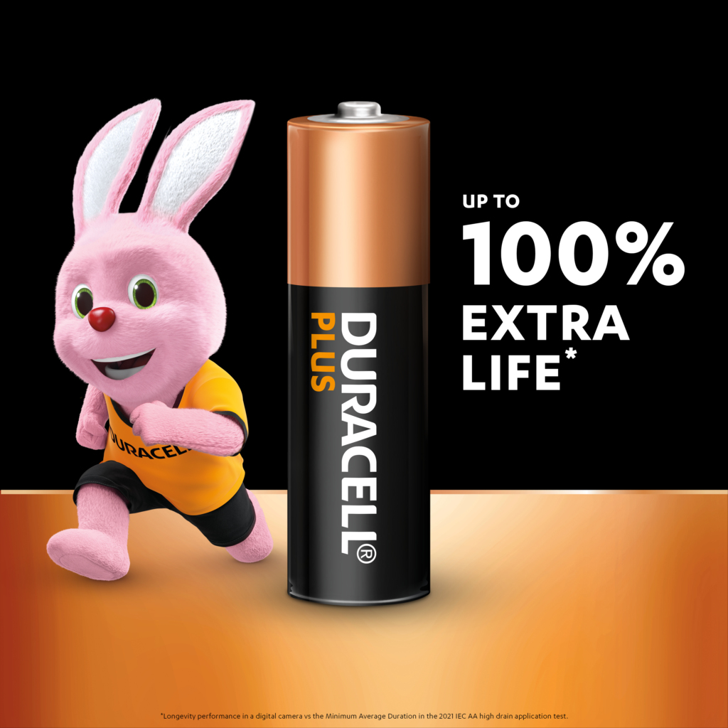 Un coniglietto rosa Duracell che corre accanto a una batteria Duracell Plus. Il testo indica il 100% di durata extra.