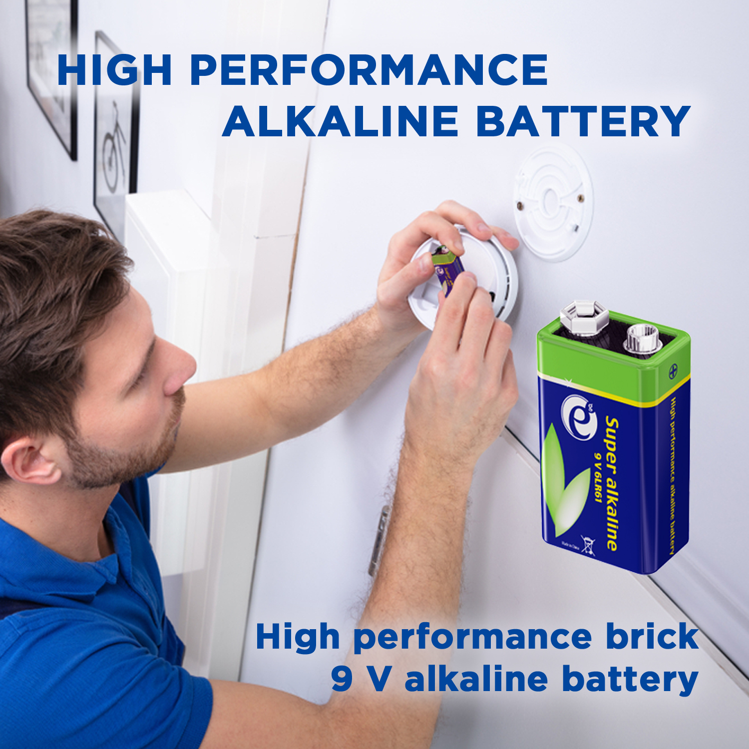 Un uomo che installa una batteria da 9V in un rilevatore di fumo su un muro bianco.