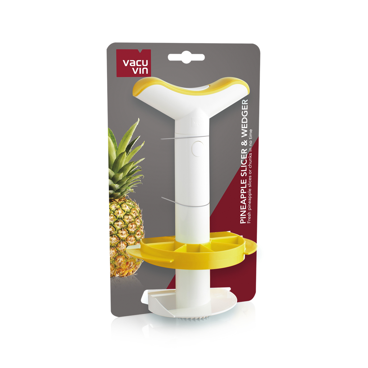 Bir pakette ananas dilimleyici ve kama aleti, arkada bir ananas ile.