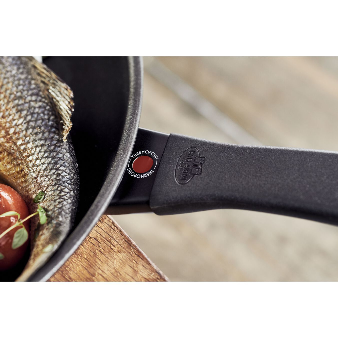 Zbliżenie uchwytu patelni z etykietą THERMOPONT.