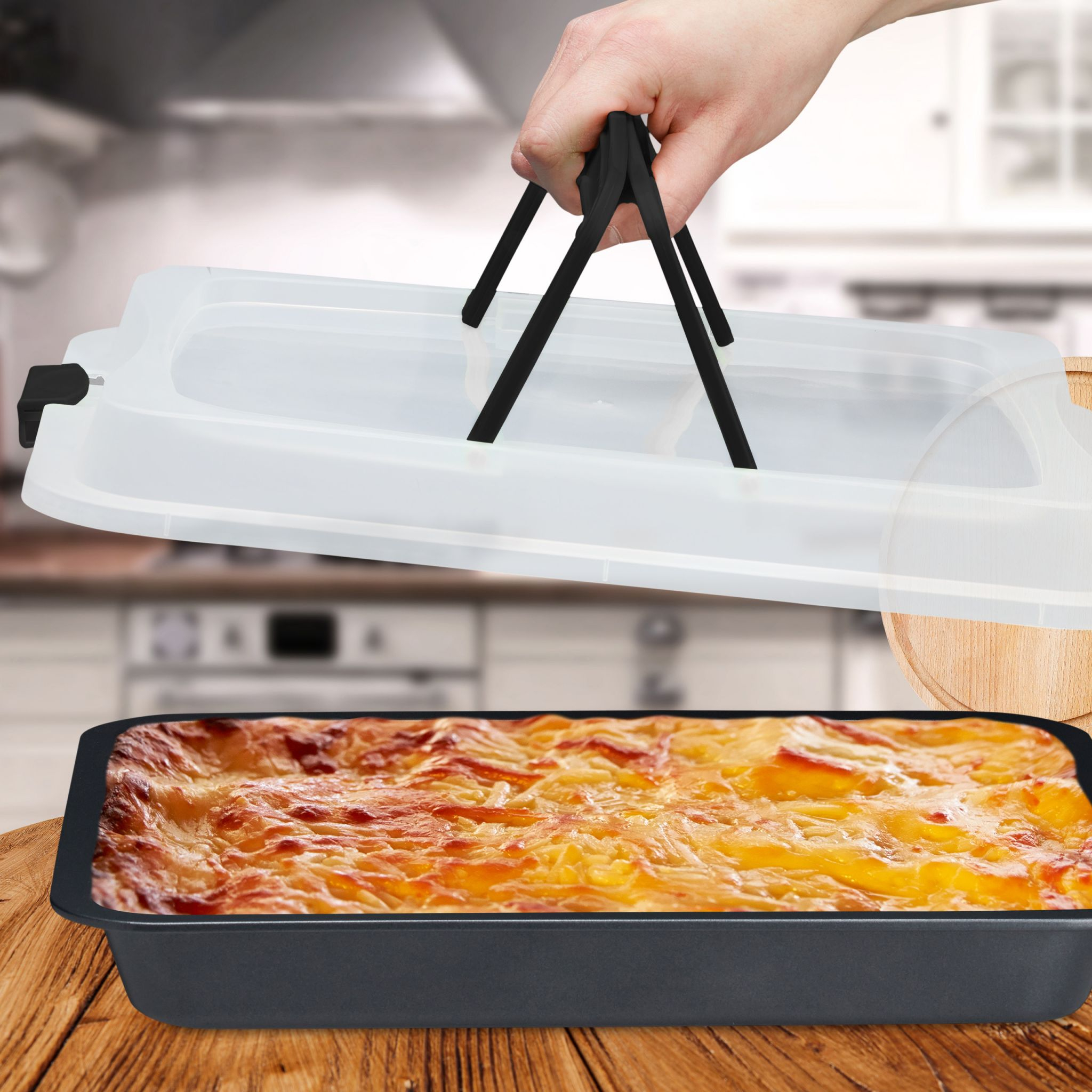 Lasagne in einer schwarzen Backform, mit Deckel. Auf einem Holztisch.