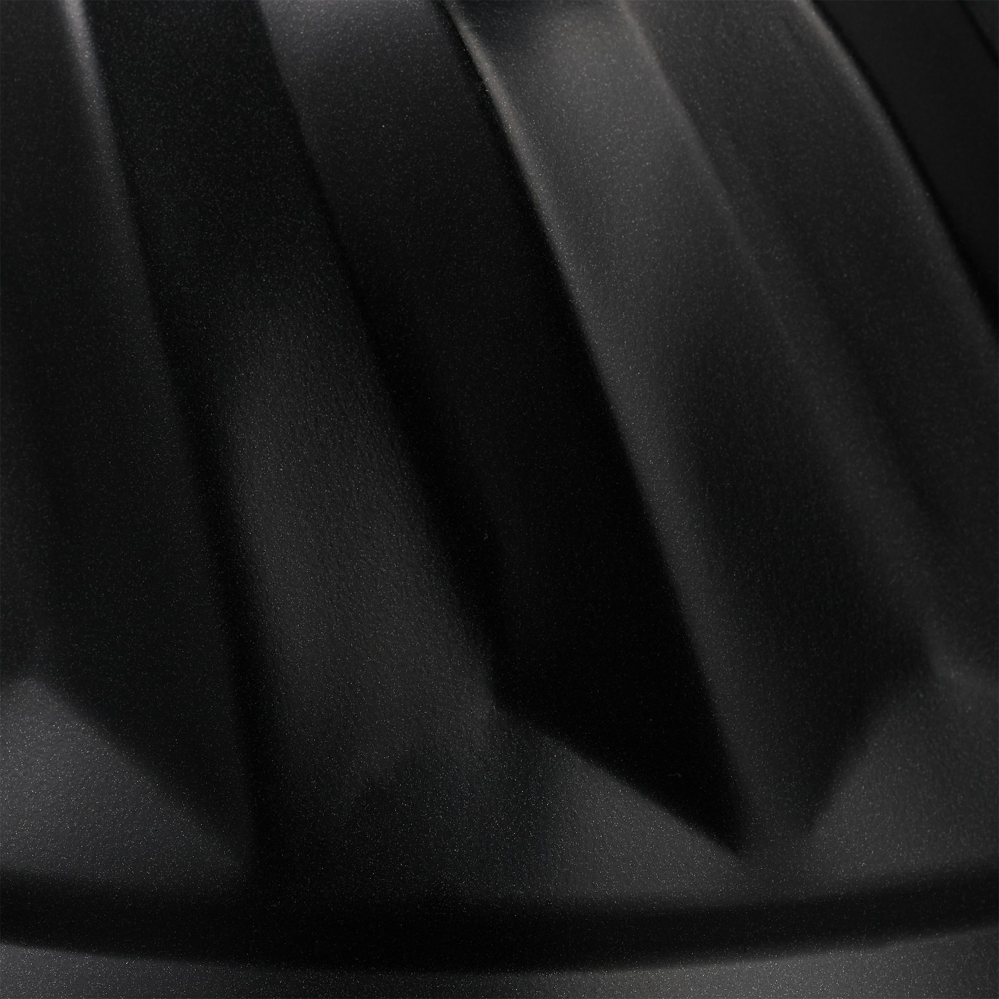 Schwarze, strukturierte Backform. Nahaufnahme. Weißer Hintergrund.