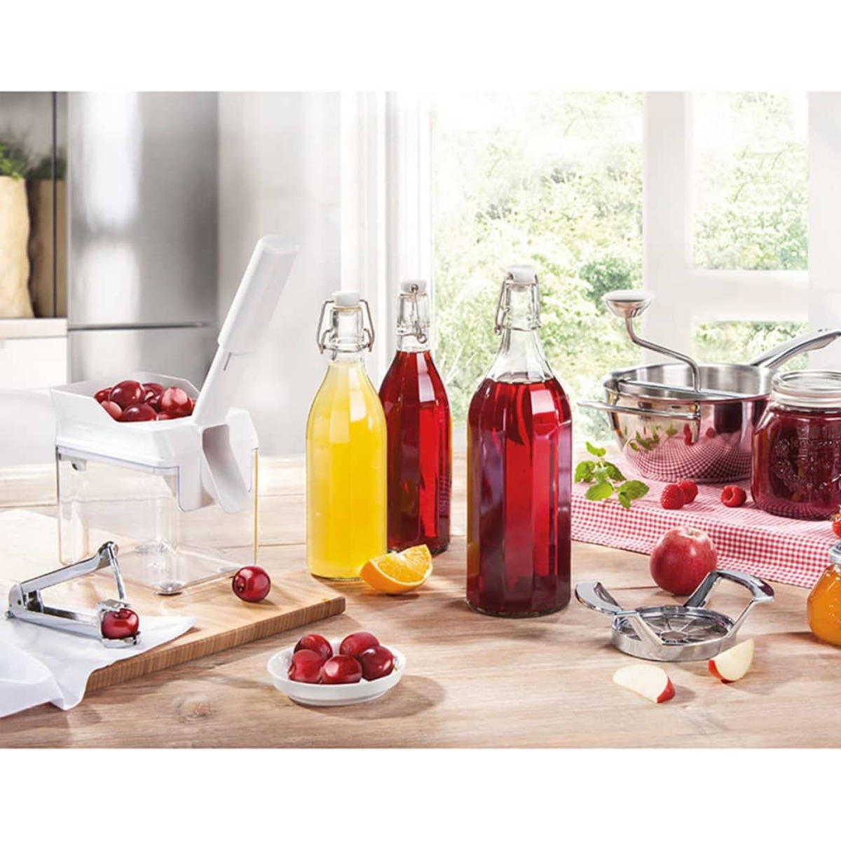 Scena kuchenna z owocami, butelkami i wyciskarką. Różne narzędzia na drewnianej powierzchni.