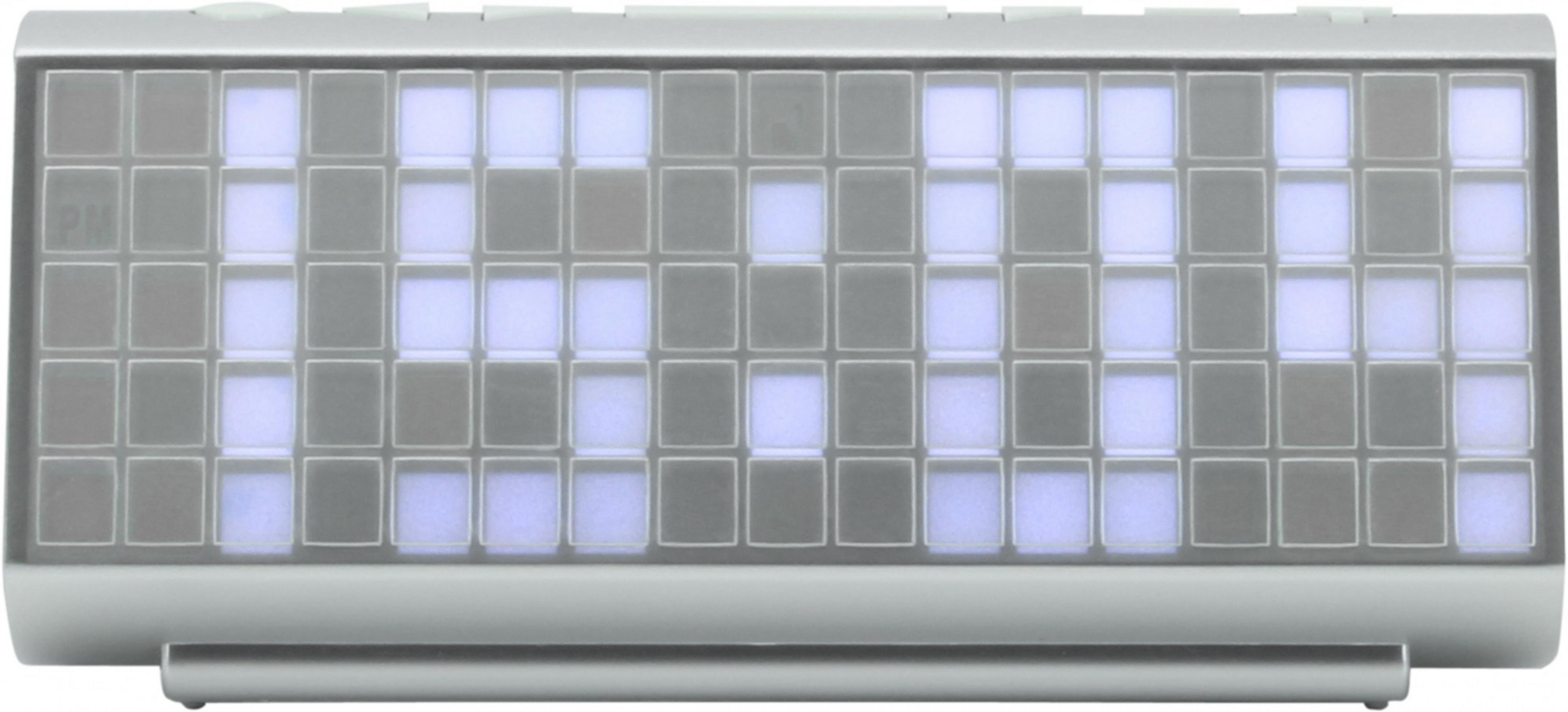 Srebrny zegar cyfrowy z niebieskim wyświetlaczem. Wyświetlacz pokazuje cyfrową godzinę ze słowem 'WALL' pośrodku.