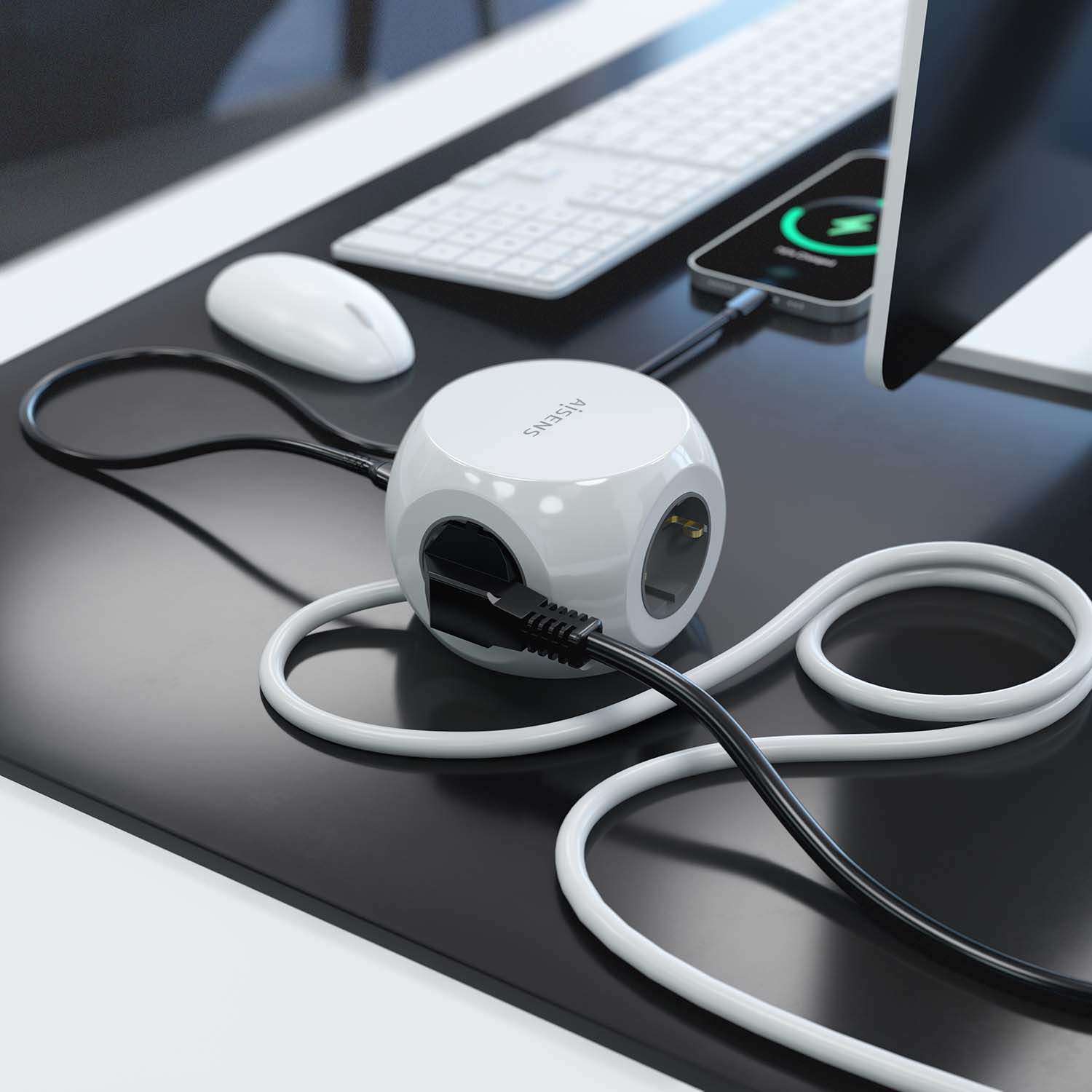 Cubo di alimentazione bianco sulla scrivania, con telefono in carica, mouse e tastiera.